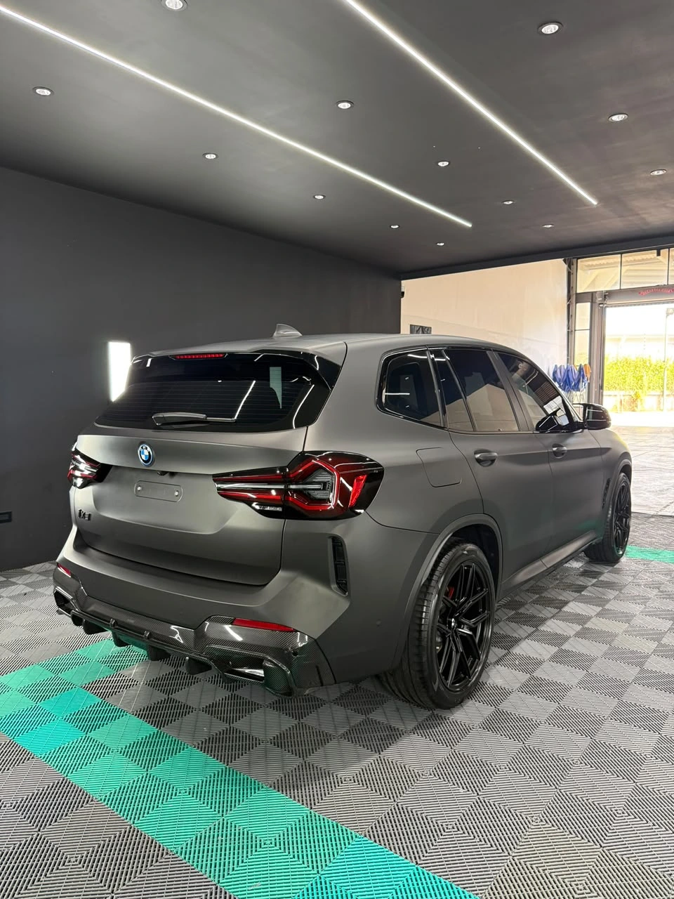 BMW iX3 con vinil gris mate en el estudio Xclusive, vista trasera desde el lado derecho